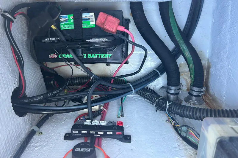 Slide: The Image of 2006 Grady-White Fisherman 222 boat battery compartment with wiring and hoses. - 13