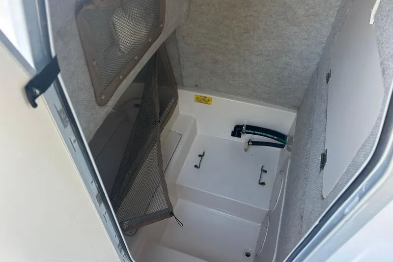 Slide: The Image of 2006 Grady-White Fisherman 222 interior storage compartment with netting and utility access. - 21