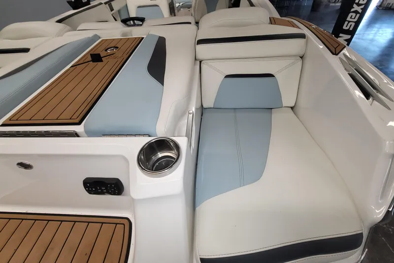 Slide: The Image of 2022 MasterCraft XStar S boat interior with white and blue seating, wood accents. - 15