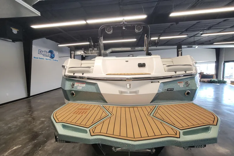 Slide: The Image of 2022 MasterCraft XStar S boat displayed in showroom with teak deck and modern design. - 6