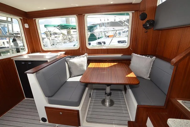 Slide: The Image of Interior of 2020 American Tug 362 with cozy seating and wooden table. - 11
