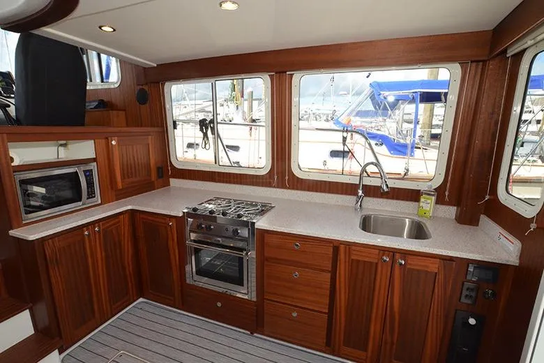 Slide: The Image of Modern kitchen interior of 2020 American Tug 362 yacht with wood cabinetry and appliances. - 13