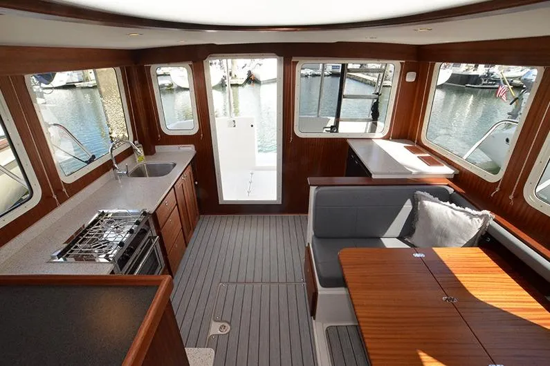 Slide: The Image of Interior of 2020 American Tug 362, featuring kitchen and dining area with marina view. - 14