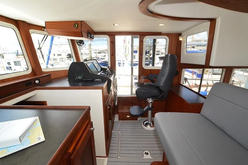Slide: The Image of Interior of 2020 American Tug 362, featuring helm station and seating area. - 16