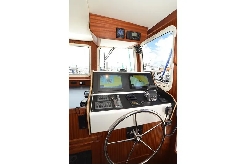 Slide: The Image of 2020 American Tug 362 helm with navigation screens and steering wheel. - 18