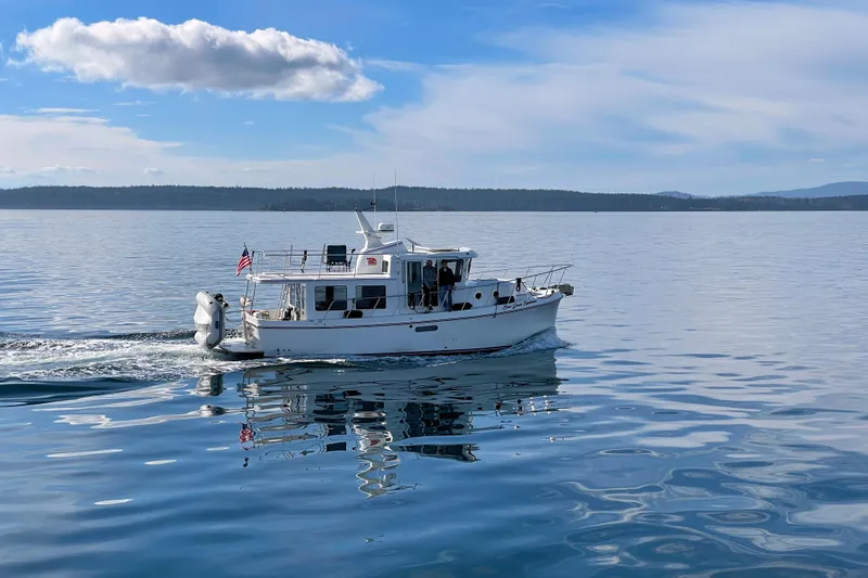 Slide: The Image of American Tug 362 (2020) cruising on calm waters under a clear blue sky. - 2