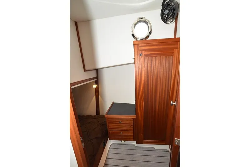 Slide: The Image of Interior of 2020 American Tug 362, featuring wooden cabinetry and a porthole window. - 20