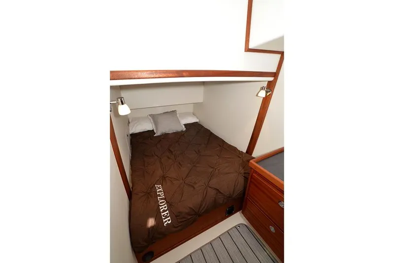 Slide: The Image of Cozy cabin interior of 2020 American Tug 362 with brown bedding and wooden accents. - 21