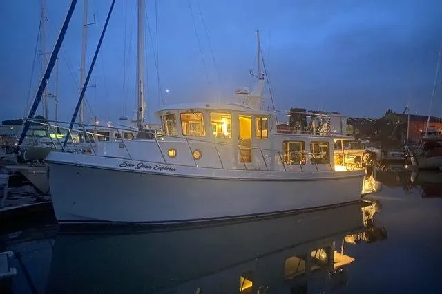 Slide: The Image of 2020 American Tug 362 boat illuminated at dusk in a marina setting. - 3