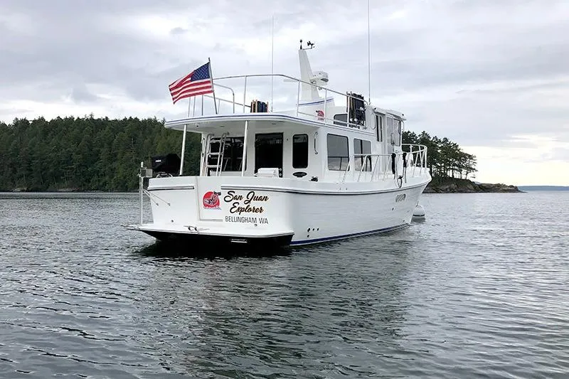 Slide: The Image of American Tug 362, 2020 model, cruising in scenic waters with forested shoreline. - 6