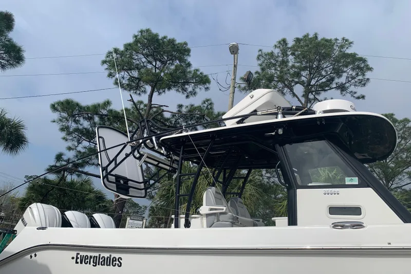 Slide: The Image of 2018 Everglades 355 Center Console boat with sleek design, set against a backdrop of trees. - 32