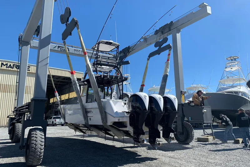 Slide: The Image of 2018 Everglades 355 Center Console boat lifted by crane in marina. - 5