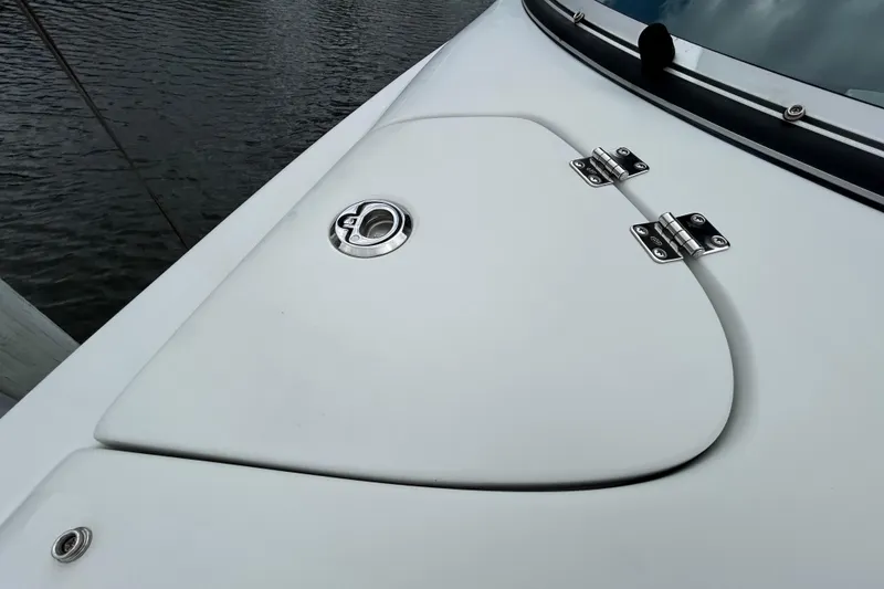 Slide: The Image of Storage compartment of 2022 Crownline 270 XSS boat with cup holders and rope. - 100