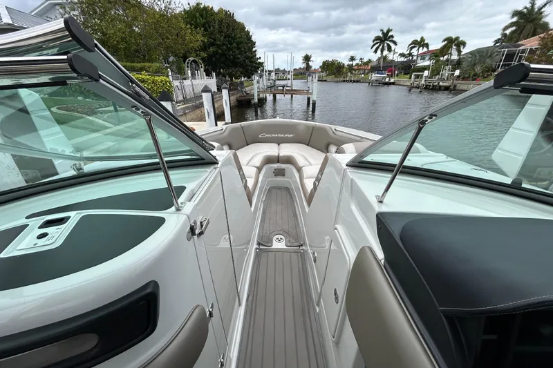 Slide: The Image of Anchor storage compartment on 2022 Crownline 270 XSS boat, featuring coiled rope and control panel. - 105