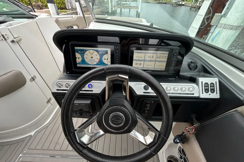 Slide: The Image of 2022 Crownline 270 XSS boat interior with storage compartment and cup holders. - 112