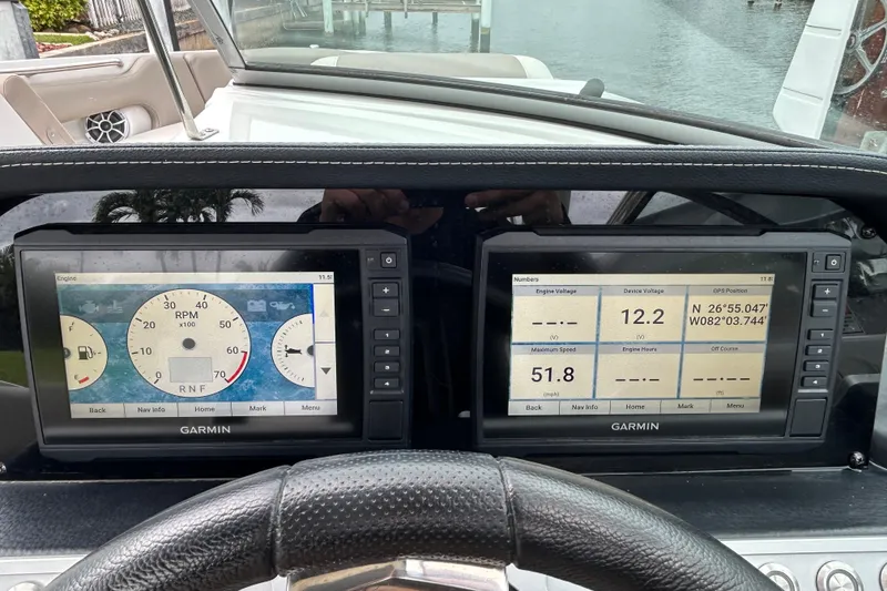 Slide: The Image of 2022 Crownline 270 XSS boat interior with seating and windshield, docked by the water. - 114