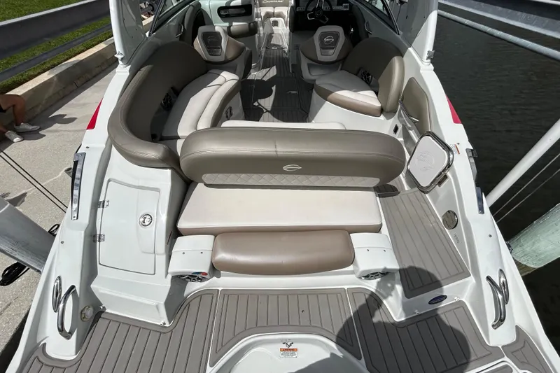 Slide: The Image of 2022 Crownline 270 XSS boat interior with seating and steering, docked by a canal. - 18
