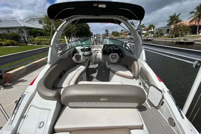 Slide: The Image of 2022 Crownline 270 XSS boat with black canopy, docked by a canal. - 19