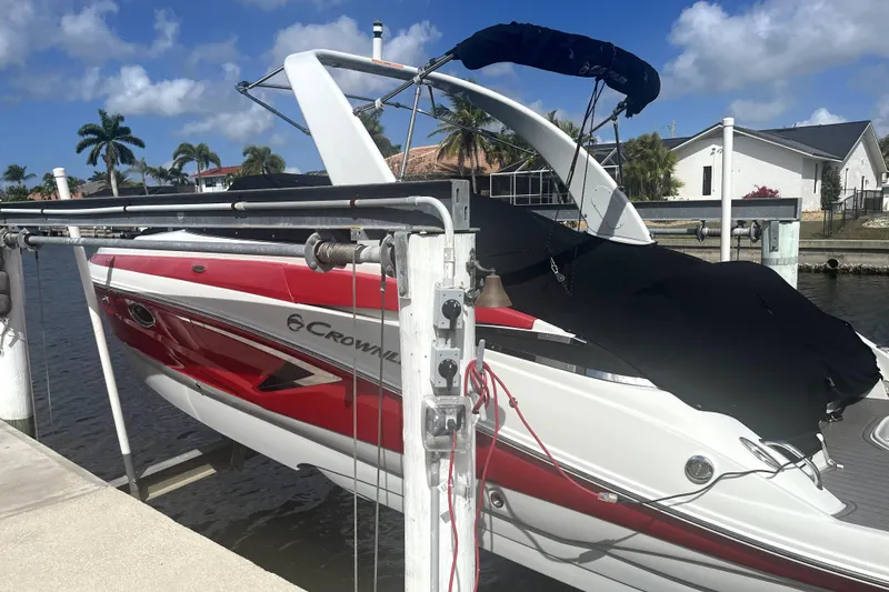 Slide: The Image of 2022 Crownline 270 XSS boat docked, featuring red and white design, under a clear sky. - 2