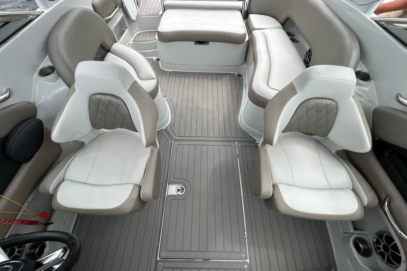 Slide: The Image of 2022 Crownline 270 XSS boat interior with cushioned seating and sleek design by the water. - 43