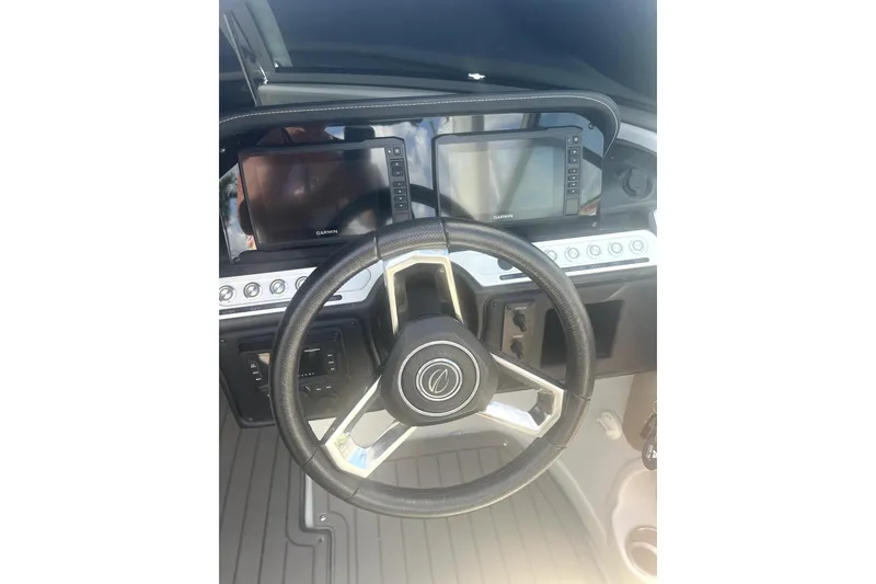 Slide: The Image of 2022 Crownline 270 XSS boat dashboard with steering wheel and dual Garmin displays. - 5