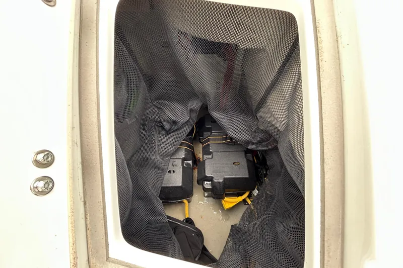 Slide: The Image of Storage compartment of 2022 Crownline 270 XSS boat with netting and equipment inside. - 53