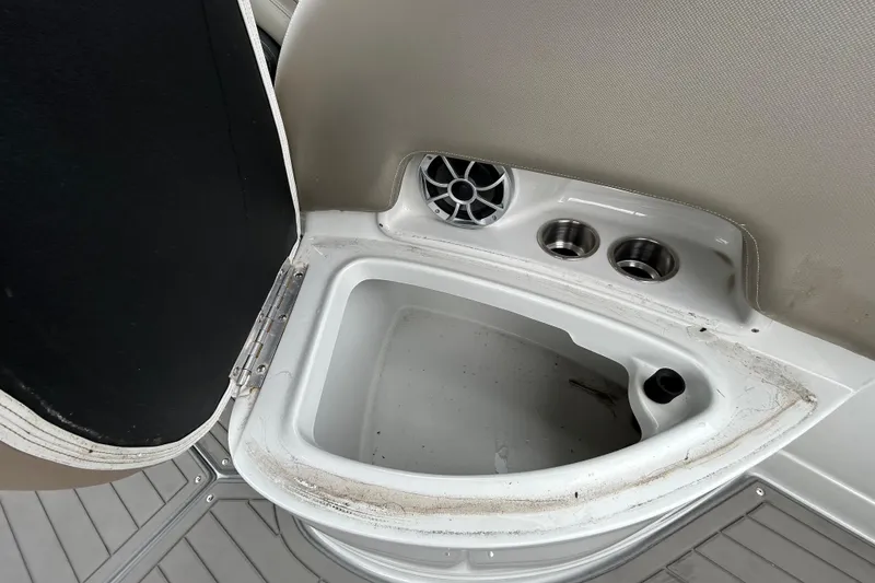 Slide: The Image of 2022 Crownline 270 XSS boat interior with storage compartment and cup holders. - 60