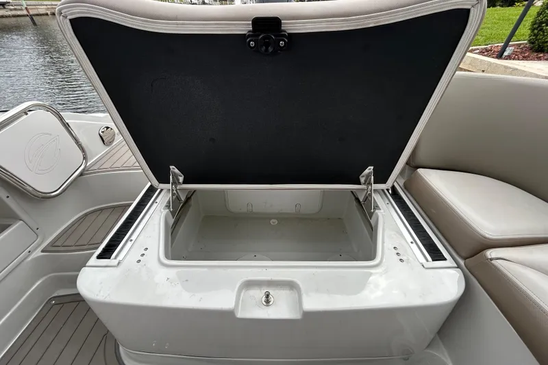 Slide: The Image of Open storage compartment on 2022 Crownline 270 XSS boat, near water. - 65