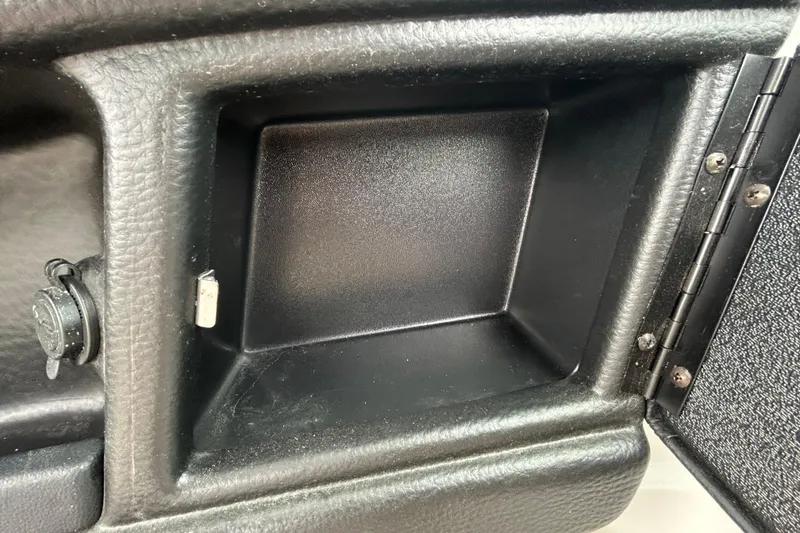 Slide: The Image of 2022 Crownline 270 XSS boat storage compartment with open door and beige interior. - 72