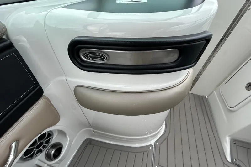 Slide: The Image of Storage compartment in 2022 Crownline 270 XSS boat, featuring black interior and hinge detail. - 73