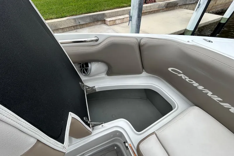 Slide: The Image of 2022 Crownline 270 XSS boat with open bow seating, docked by a scenic canal. - 91
