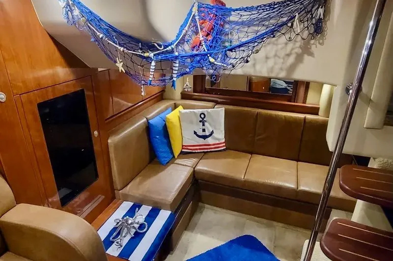 Slide: The Image of 2005 Sea Ray 390 Sundancer interior with nautical decor and cozy seating area. - 11