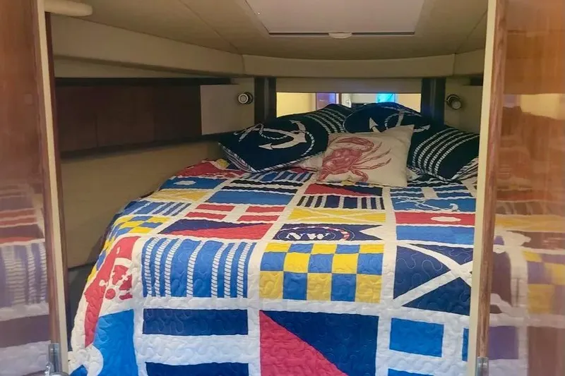 Slide: The Image of Cozy cabin interior of 2005 Sea Ray 390 Sundancer with colorful nautical bedding. - 13