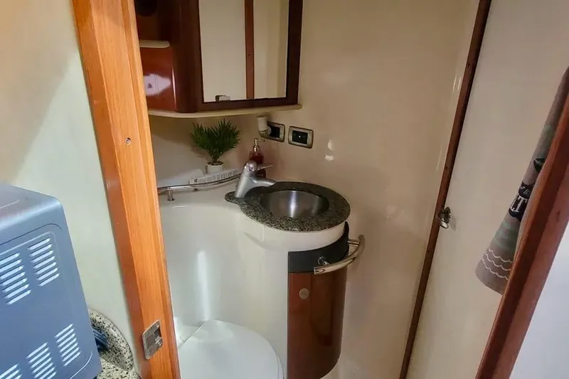 Slide: The Image of 2005 Sea Ray 390 Sundancer bathroom with sink, mirror, and wooden accents. - 14