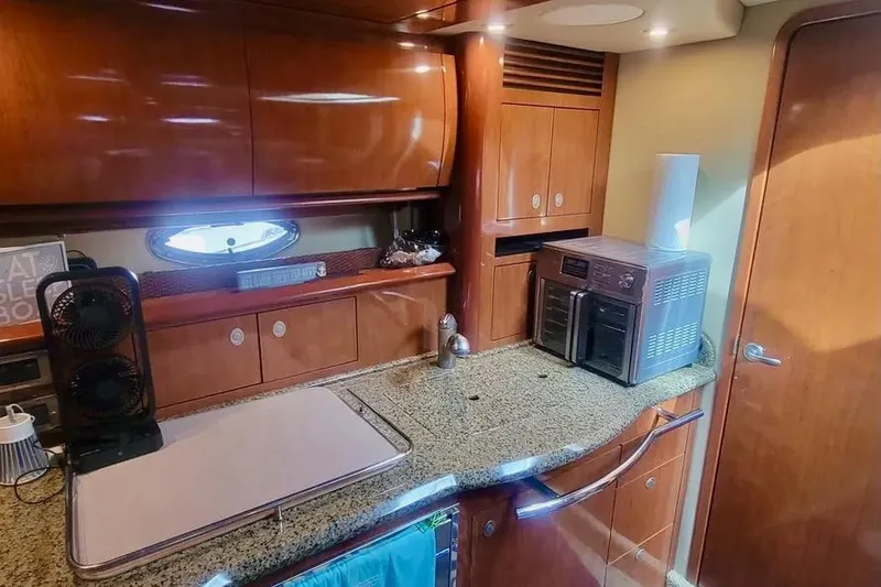 Slide: The Image of 2005 Sea Ray 390 Sundancer yacht kitchen with granite countertops and modern appliances. - 15
