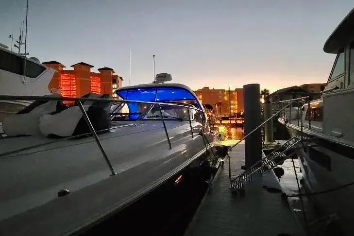 Slide: The Image of 2005 Sea Ray 390 Sundancer docked at sunset with illuminated blue interior. - 6