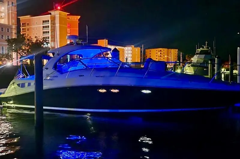 Slide: The Image of 2005 Sea Ray 390 Sundancer yacht illuminated at night in a marina setting. - 7
