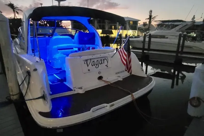 Slide: The Image of 2005 Sea Ray 390 Sundancer docked at sunset with blue interior lighting. - 8