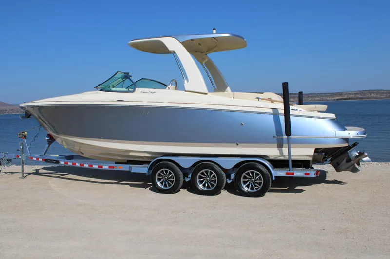 Slide: The Image of 2025 Chris Craft Launch 28 GT boat on trailer by the water. - 2