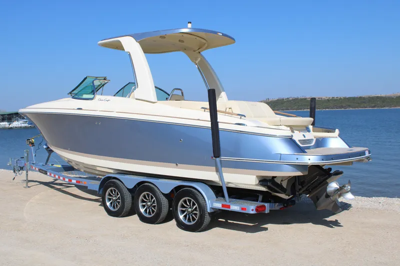 Slide: The Image of 2025 Chris Craft Launch 28 GT boat on trailer by the water. - 3