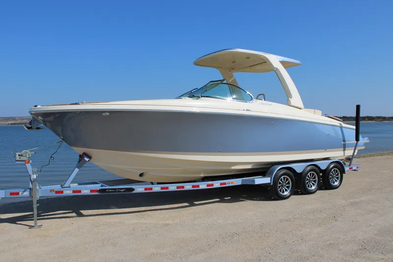 Slide: The Image of 2025 Chris Craft Launch 28 GT boat on trailer by the water. - 5