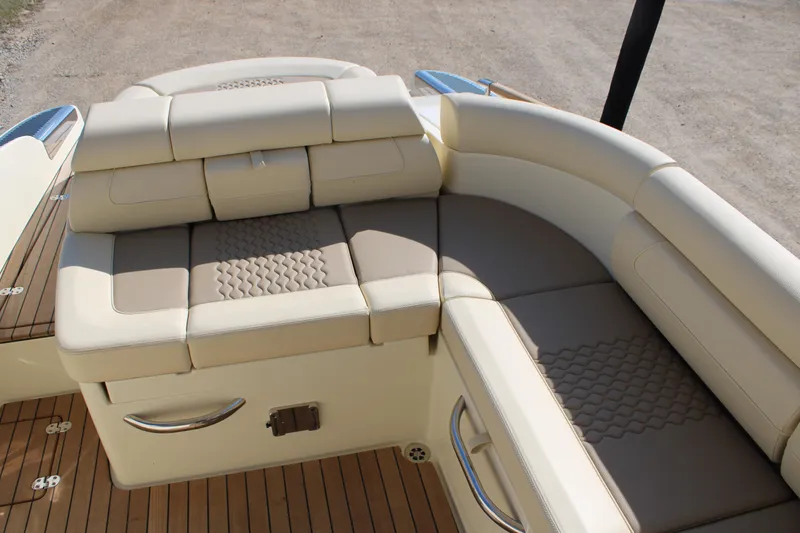 Slide: The Image of 2025 Chris Craft Launch 28 GT boat interior with beige leather seating and wooden flooring. - 9
