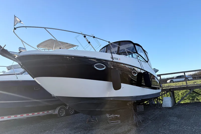 The Image of 2002 Maxum 3100 SE boat on dry dock under clear blue sky. - 0