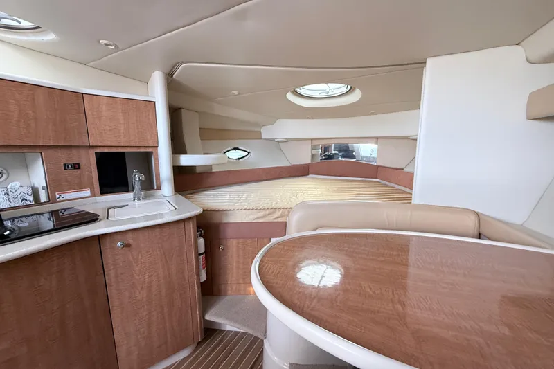 Slide: The Image of 2002 Maxum 3100 SE cabin interior with kitchenette, dining area, and sleeping space. - 15