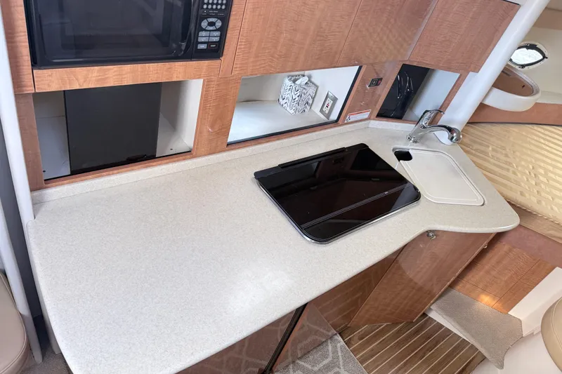 Slide: The Image of 2002 Maxum 3100 SE boat interior kitchen with microwave, sink, and stove. - 16
