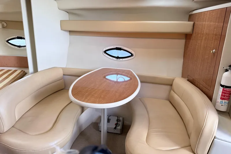 Slide: The Image of 2002 Maxum 3100 SE cabin interior with beige seating and wooden table. - 17