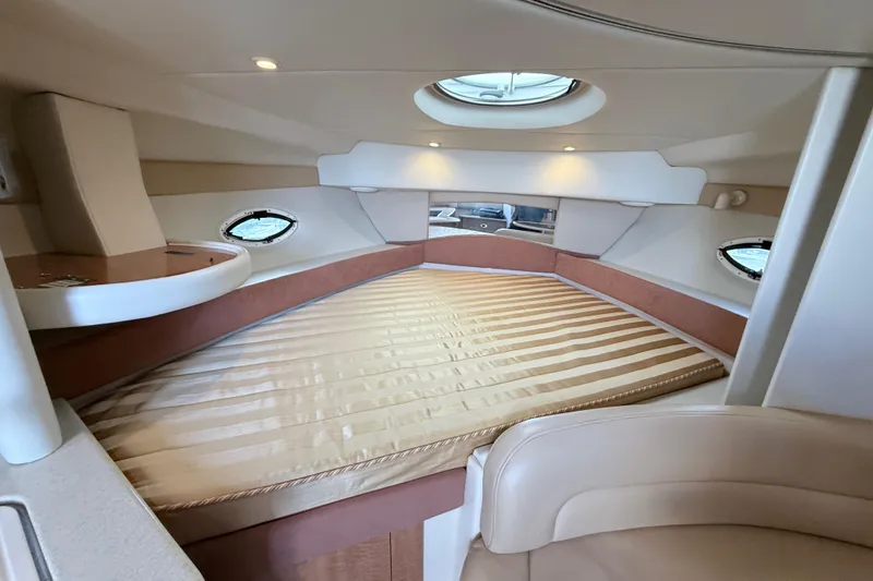 Slide: The Image of 2002 Maxum 3100 SE cabin interior with circular bed and porthole windows. - 21