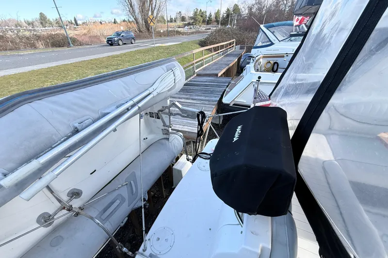 Slide: The Image of 2002 Maxum 3100 SE boat docked with inflatable dinghy and covered equipment. - 3