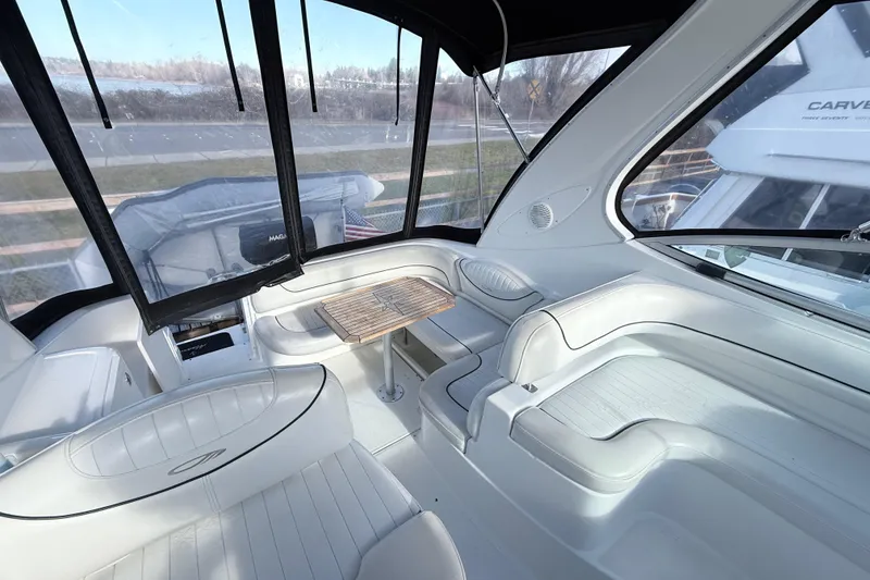 Slide: The Image of 2002 Maxum 3100 SE boat interior with white seating and wooden table. - 5