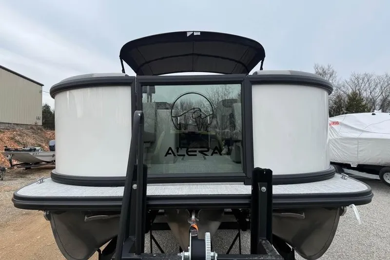 Slide: The Image of 2026 Alara 22Q pontoon boat with sleek design and canopy, parked outdoors. - 2